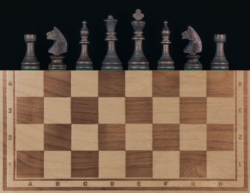 Top view of a wooden chessboard with alternating light and dark squares