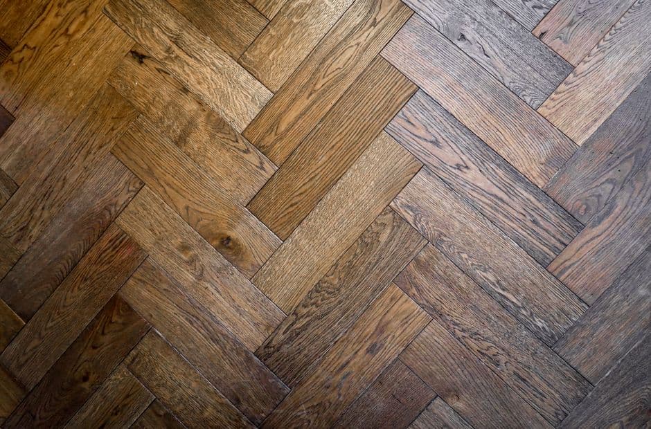 Close-up of an oak herringbone parquet floor, showing square-cut blocks meeting at right angles