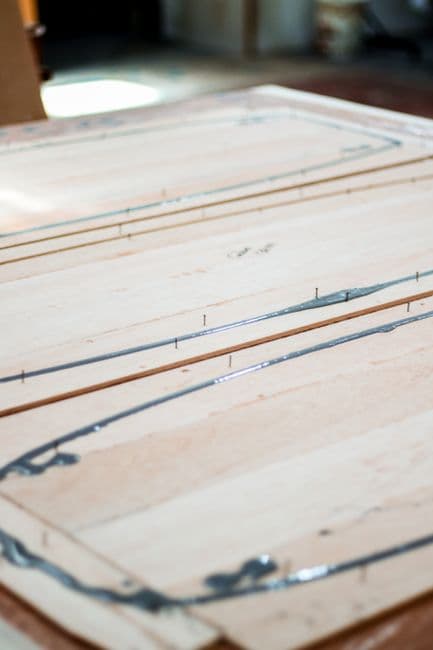 Glue squeezed out along the joints of a light coloured wooden panel