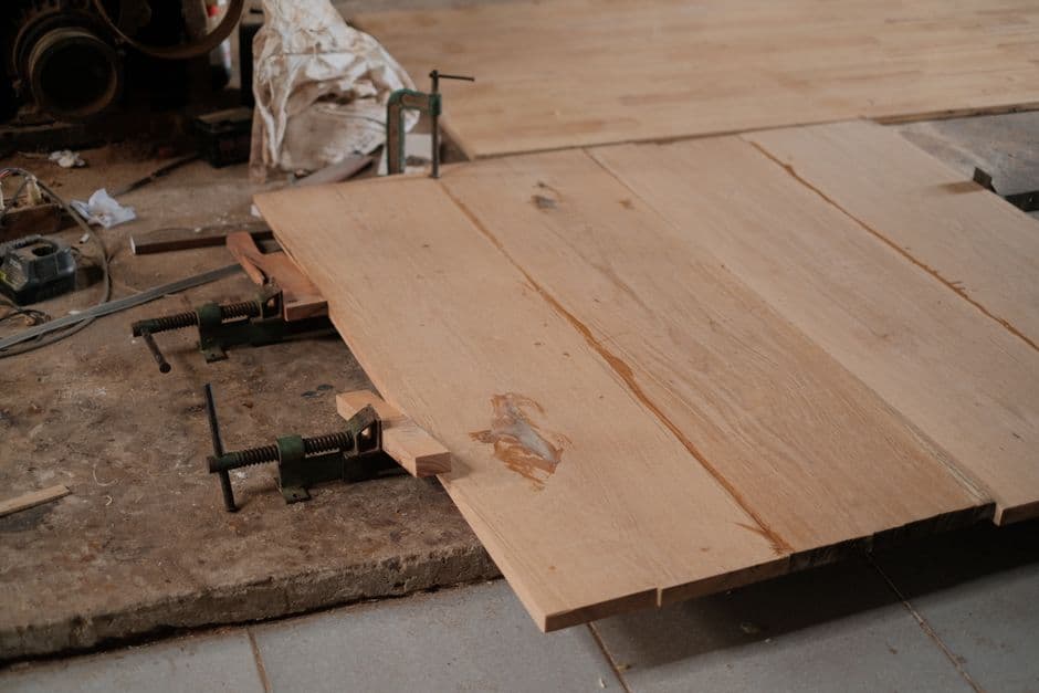 Wooden strips clamped edge to edge on a workbench during a panel glue-up